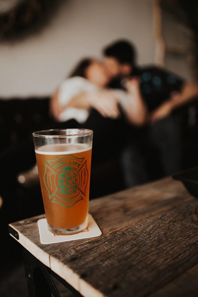 Hop Life brewing company beer glass with couple blurred out in background