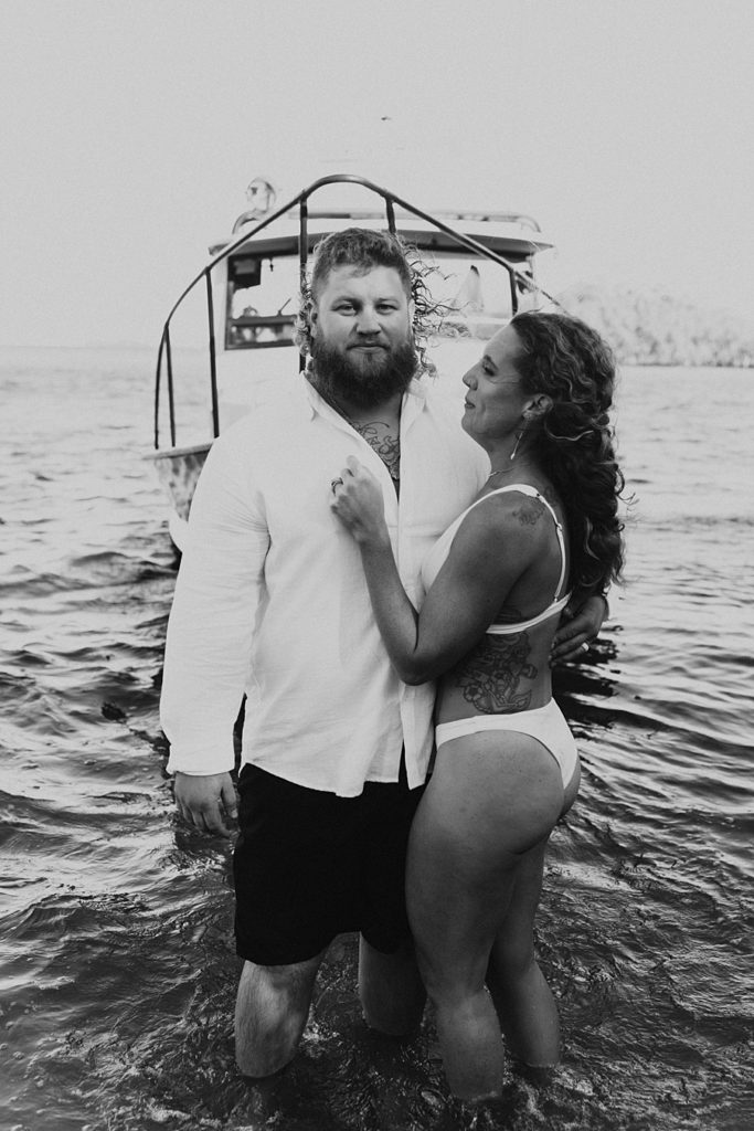 Bride and groom posing in front of fishing boat