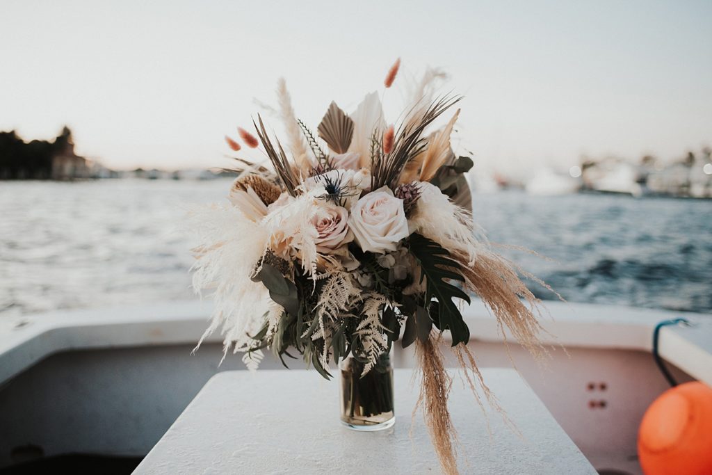 Florida elopement bouquet with roses and dried florals on boat