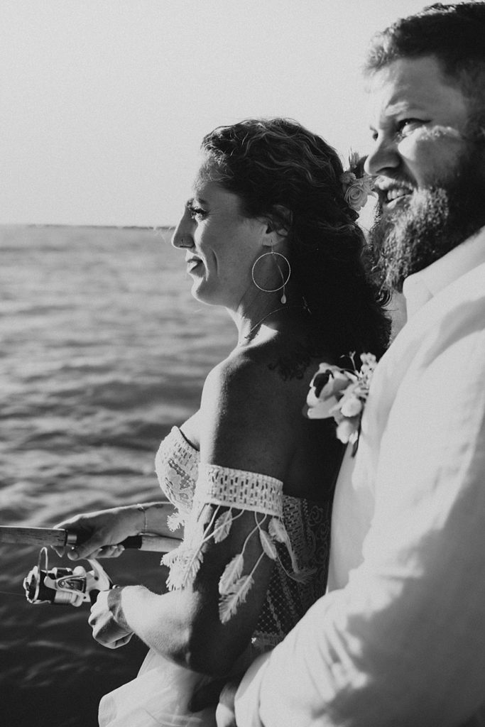 Bride and groom fishing on back of boat