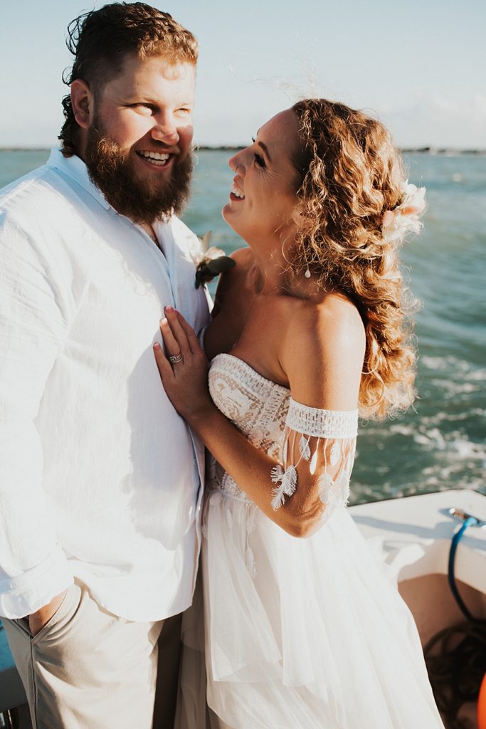 Bride and groom laughing on boat