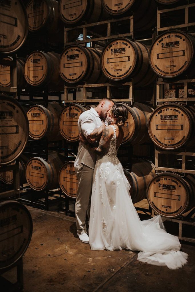 Bride and groom kissing in front of barrels