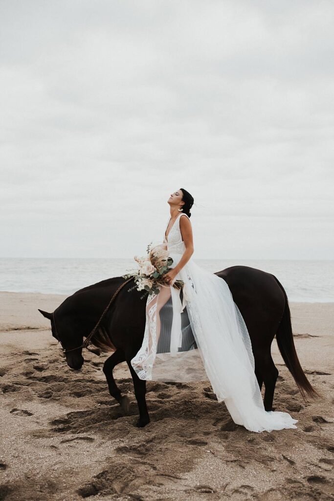 Bride sitting on her horse with her floral bouquet at a Florida beach
