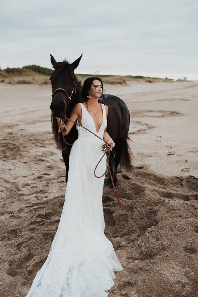 Florida bride holding horse at the beach