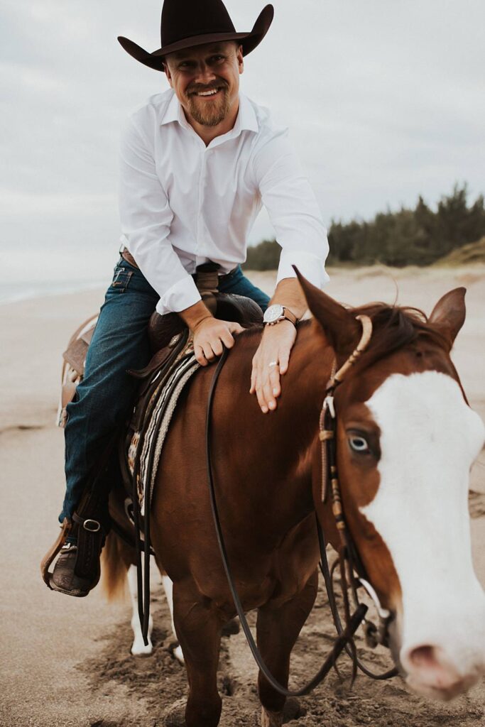 Groom sitting on horse at the beach