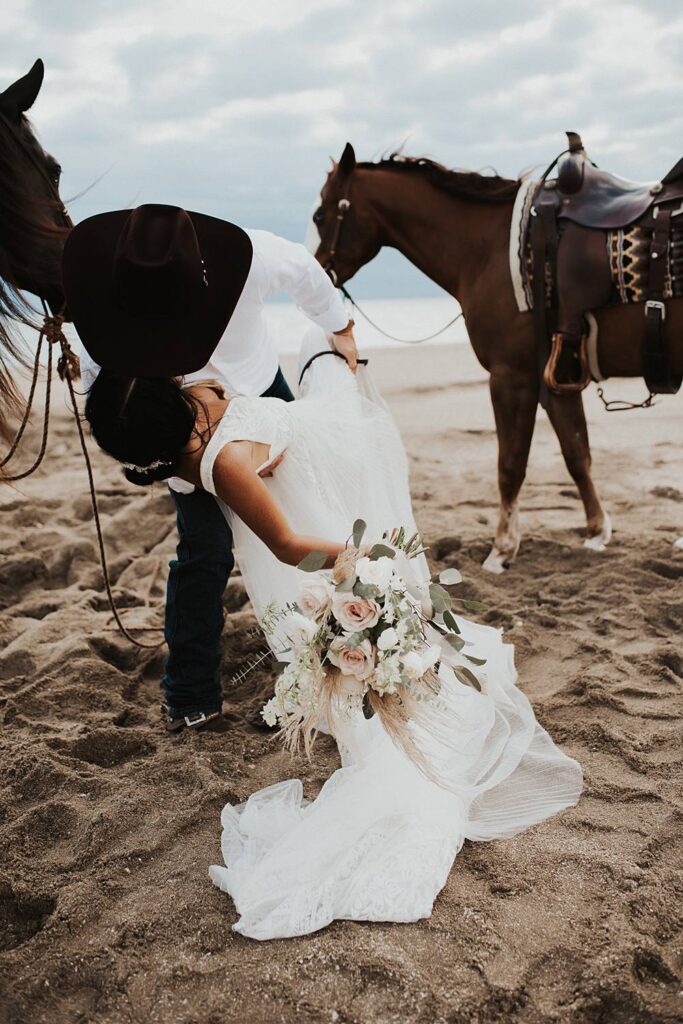 Bride and groom first kiss on Florida beach during their elopement with their horses