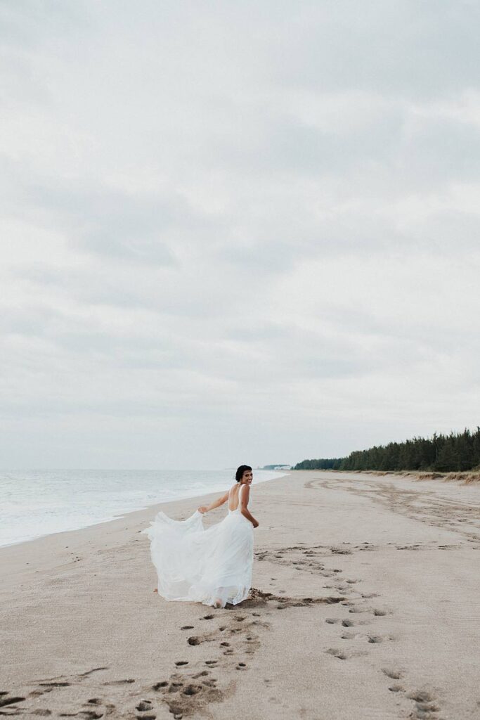 Bridal portrait on the beach at sunrise with neutral floral bouquet