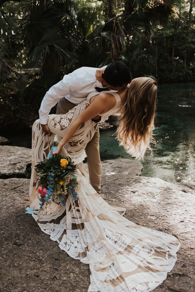 Bride and groom with spring floral bouquet at Kelly Park Rock Springs in Apopka Florida during her elopement
